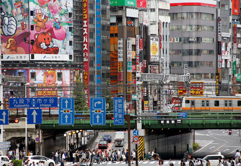 © Reuters. People cross the street  at a shopping district  in Tokyo