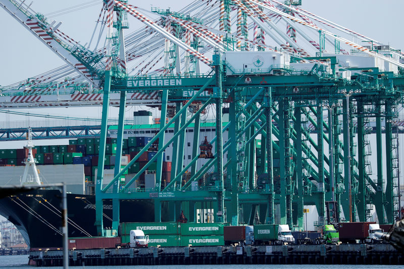 © Reuters. FILE PHOTO: Trucks offload containers from ship at the port of Los Angeles in Los Angeles, California