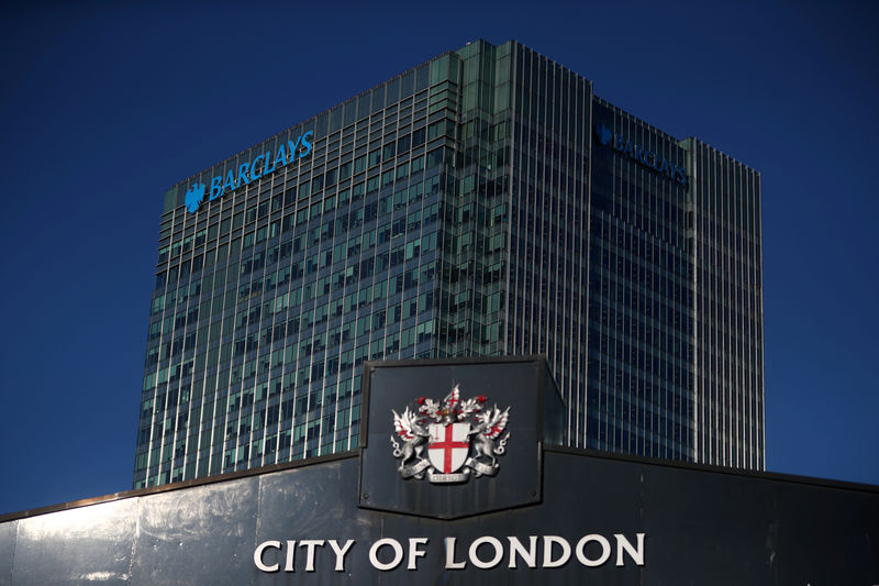 © Reuters. FILE PHOTO: Barclays' building in Canary Wharf is seen behind a City of London sign outside Billingsgate Market in London