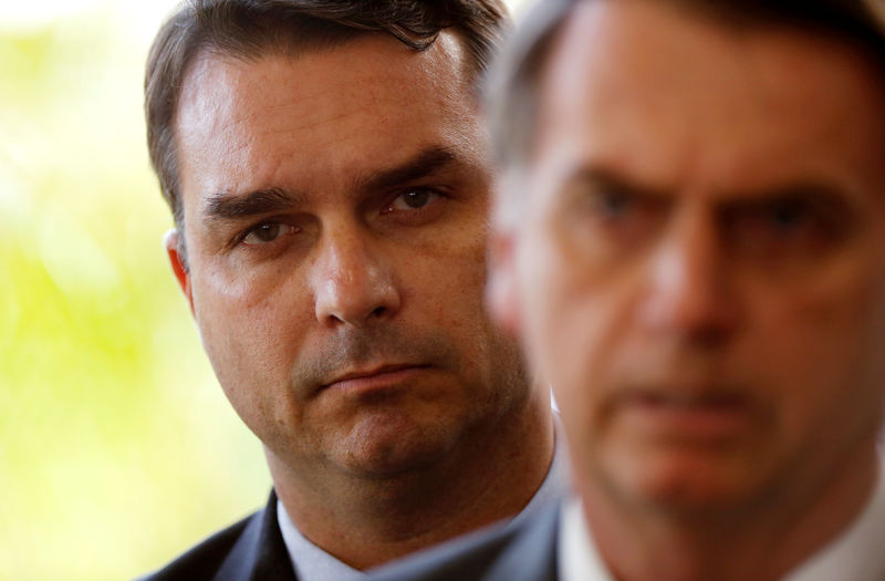 © Reuters. Flávio Bolsonaro, filho do presidente eleito Jair Bolsonaro, atrás do pai no prédio do governo de transição em Brasília