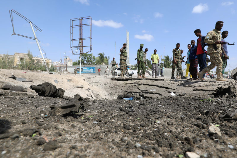 © Reuters. Foto del sábado de las fuerzas de seguridad somalíes y civiles cerca del lugar donde se produjo una explosión en la capital somalí