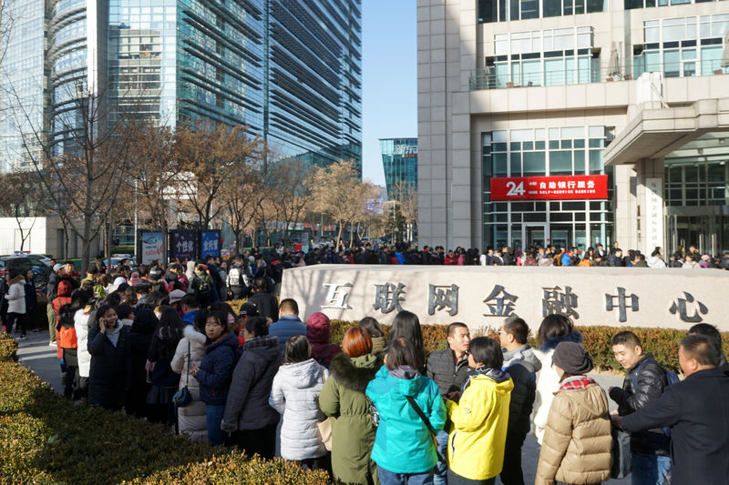 © Reuters. FILE PHOTO: People queue for deposit refunds outside the headquarters of bike-sharing company Ofo in Beijing