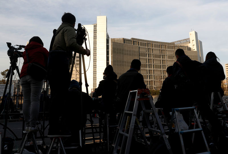 © Reuters. Members of media crews are seen on step ladders in front of the Tokyo Detention Center, where Nissan's arrested chairman Carlos Ghosn and a former Nissan executive Greg Kelly are being held, in Tokyo