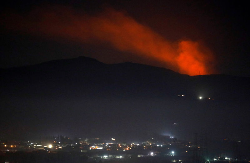 © Reuters. Fumaça vista atrás de montanha em Damasco