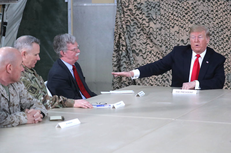 © Reuters. U.S. President Trump, flanked by National Security Adviser Bolton, meets political and military leaders during an unannounced visit to Al Asad Air Base, Iraq