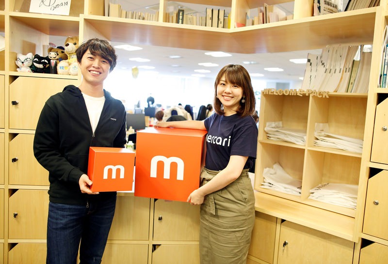 © Reuters. Employees of Mercari Inc. Takashi Murakami and Ayano Okuda pose for a photograph at the company office in Tokyo