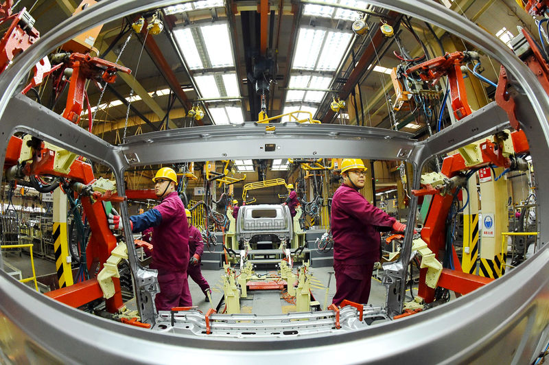 © Reuters. FILE PHOTO:  Employees work on a production line manufacturing light trucks at a JAC Motors plant in Weifang