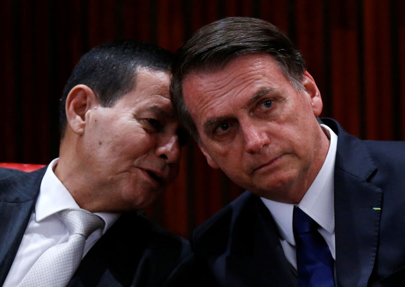 © Reuters. O presidente eleito, Jair Bolsonaro, ouve seu vice-presidente eleito, Hamilton Mourão, em Brasília