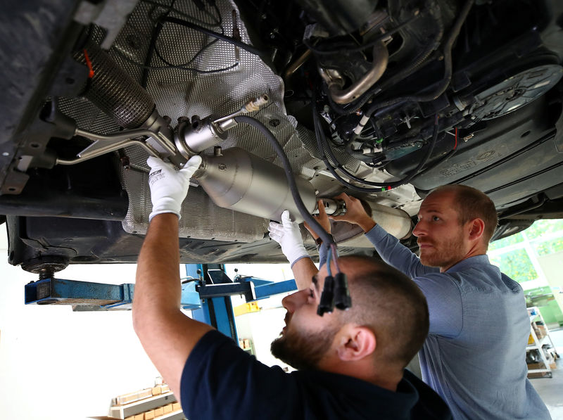 © Reuters. Employees of "Oberland Mangold Katalysatortechnik" mount a particulate catalytic converter at a Diesel car in Eschenlohe