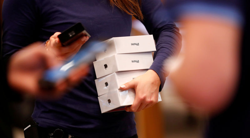 © Reuters. FILE PHOTO: Apple staff hold iPhone X packages at the Apple Store in Berlin