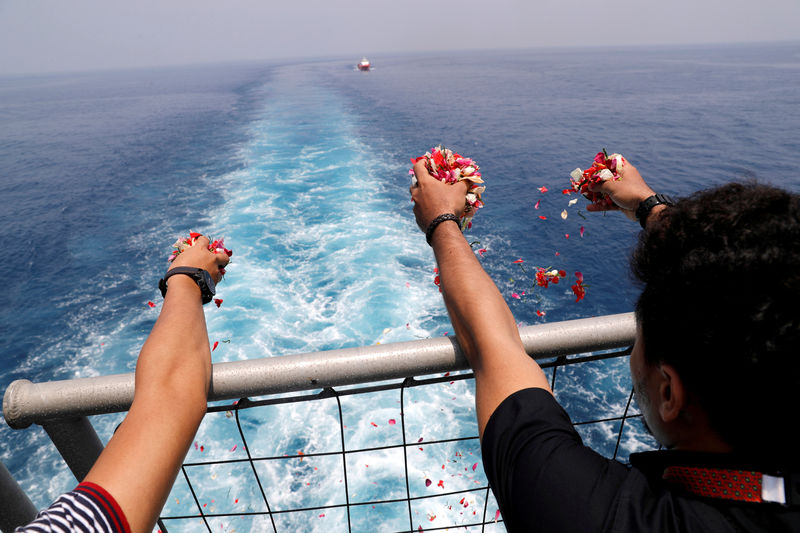 © Reuters. FILE PHOTO: Families and colleagues of passengers and crew of Lion Air flight JT610 throw flowers and petals from the deck of Indonesia Navy ship KRI Banjarmasin as they visit the site of the crash to pay their tribute, at the north coast of Karawang