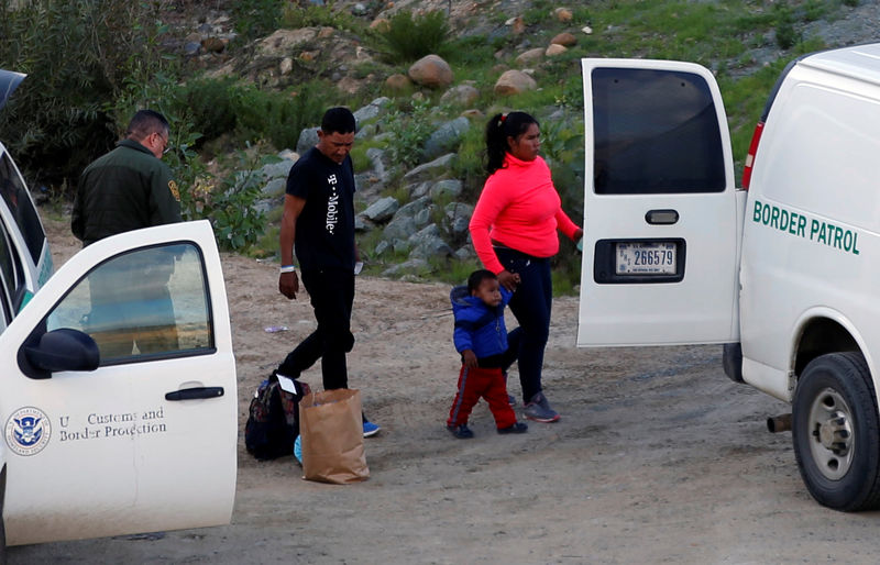 © Reuters. Funcionarios de la Oficina de Aduanas y Protección Fronteriza detienen a migrantes tras saltar una cerca para ingresar ilegalmente a Estados Unidos desde México