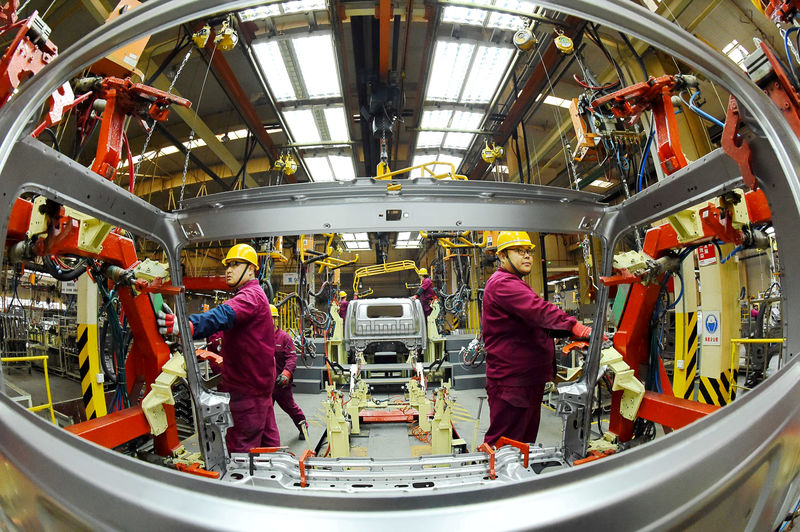 © Reuters. FILE PHOTO: Employees work on a production line manufacturing light trucks at a JAC Motors plant in Weifang