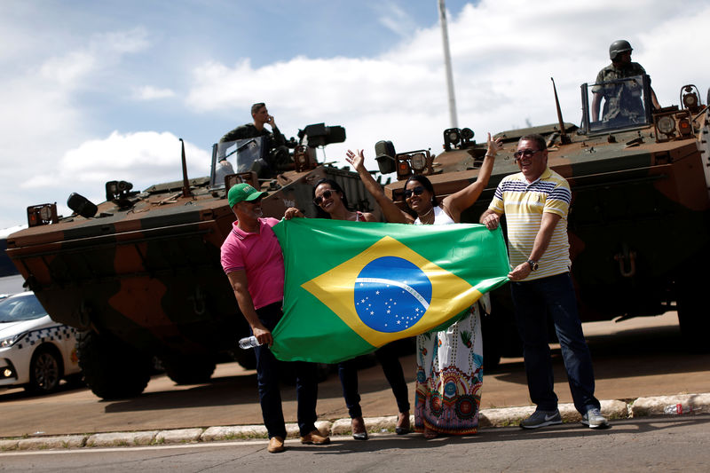 © Reuters. Pessoas fazem pose para foto diante de blindados em Brasília durante preparativos para a cerimônia de posse do presidente eleito Jair Bolsonaro