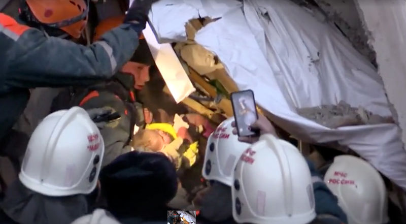 © Reuters. A still image taken from a video footage shows a rescuer carries a 10-month-old child found alive in the rubble of a Russian apartment block that partially collapsed after a suspected gas blast in Magnitogorsk