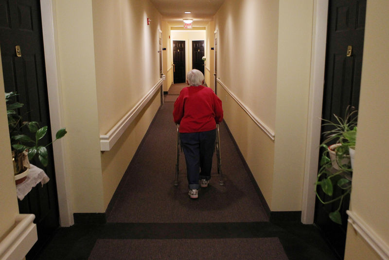 © Reuters. FILE PHOTO: Inez Willis walks down the hallway to visit a neighbor at her independent living complex in Maryland