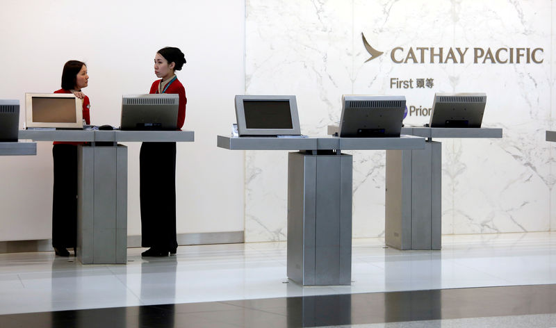 © Reuters. FILE PHOTO: Attendants chat at the First Class counter of Cathay Pacific Airways at Hong Kong Airport in Hong Kong