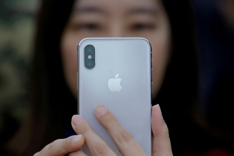 © Reuters. FILE PHOTO: An attendee uses a new iPhone X during a presentation for the media in Beijing