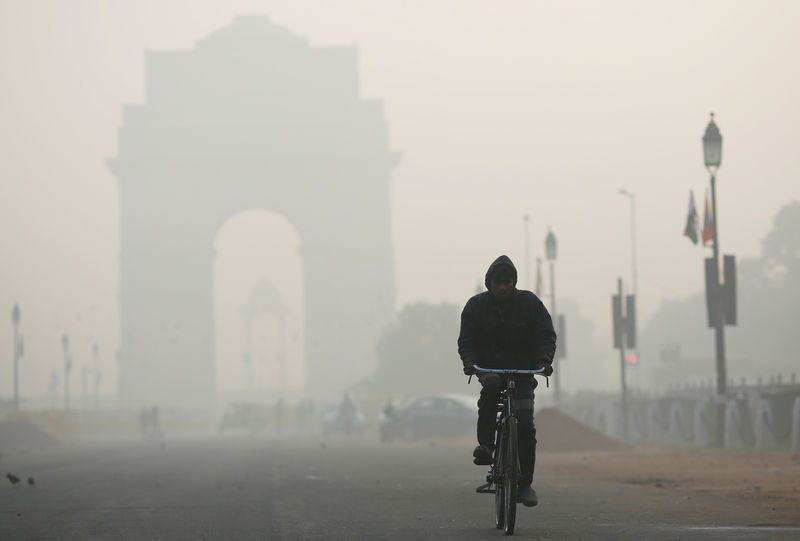 © Reuters. Homem passeia de bibicleta sob neblina em Nova Délhi