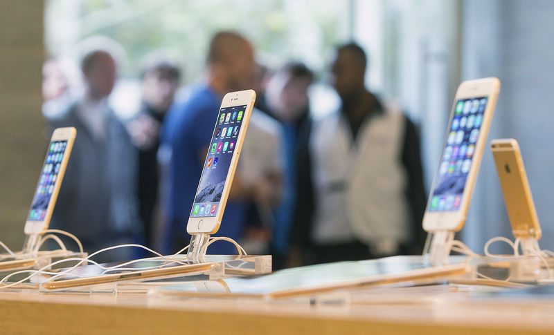 © Reuters. Customers stand in line at the Apple store in Berlin, as they wait to buy the newly released iPhone 6