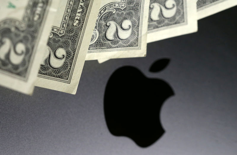 © Reuters. Photo illustration of U.S. dollar banknotes in front of the Apple logo