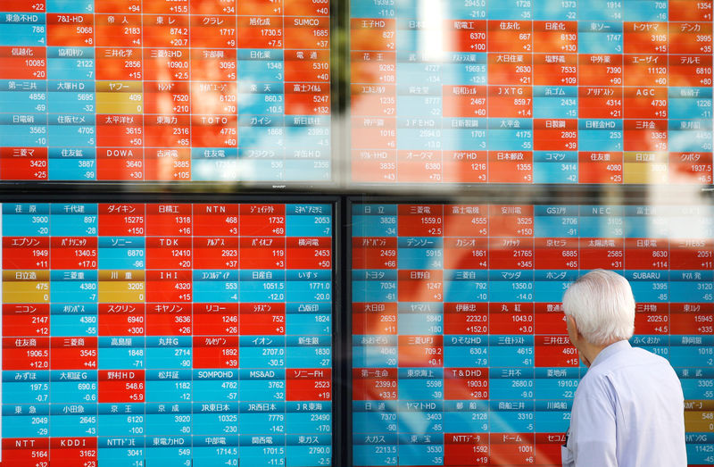 © Reuters. A man looks at an electronic stock quotation board outside a brokerage in Tokyo