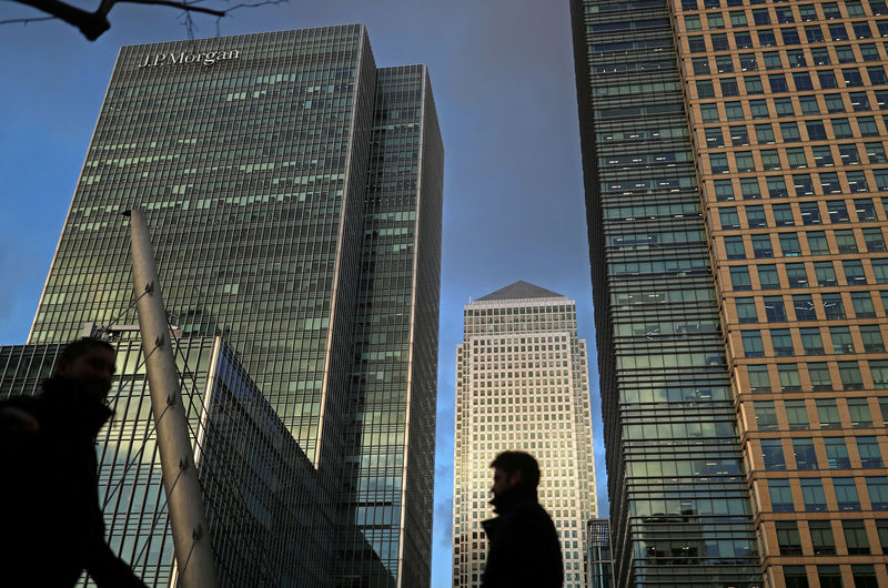 © Reuters. FILE PHOTO: People walk through the Canary Wharf financial district of London