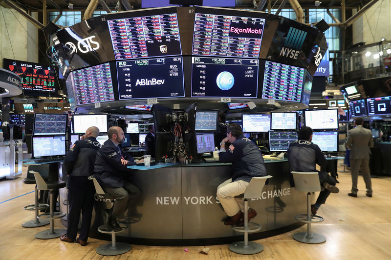 © Reuters. Traders look at price monitors as they work on the floor at the New York Stock Exchange (NYSE) in New York City