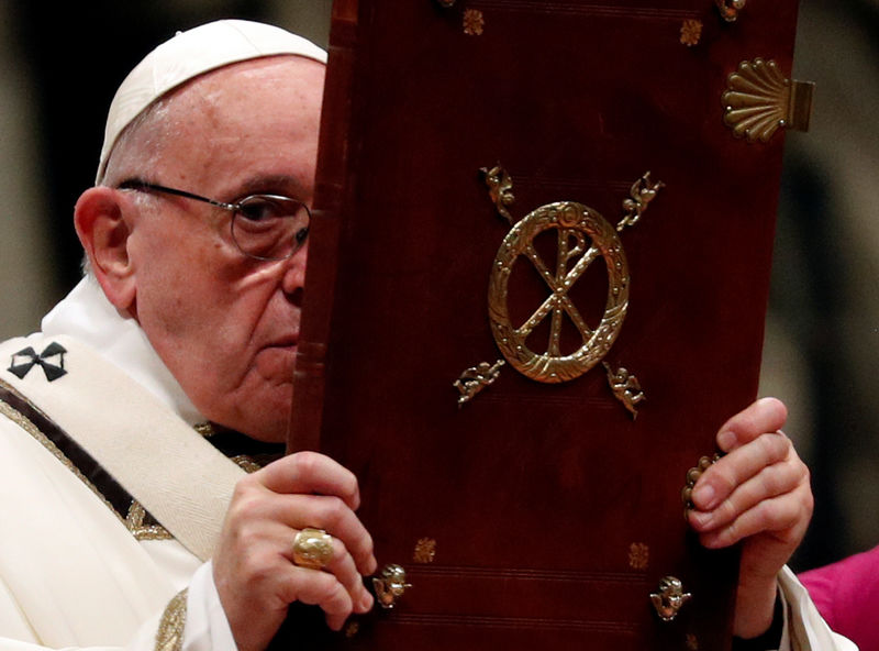 © Reuters. Papa Francisco segura  livro durante missa na Basílica de São Pedro, no Vaticano, na noite de Natal