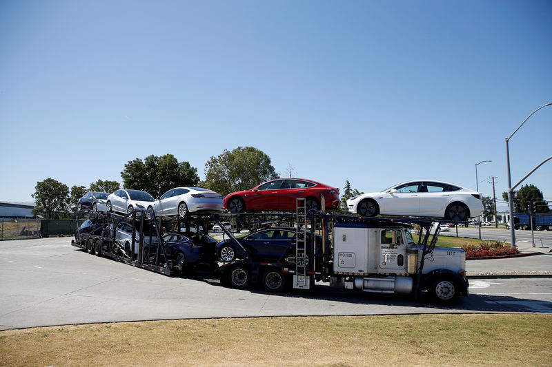 © Reuters. FILE PHOTO: A car carrier trailer carries Tesla Model 3 electric sedans, is seen outside the Tesla factory in Fremont