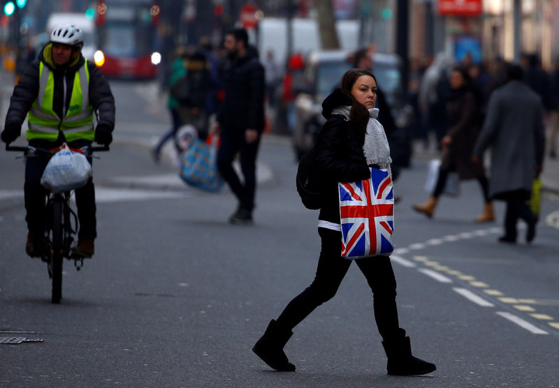 © Reuters. FILE PHOTO: A woman carries shopping in a plastic bag, in London