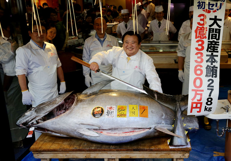 © Reuters. Kiyomura Co's President Kiyoshi Kimura, who runs a chain of sushi restaurants Sushi Zanmai, poses as he prepares to cut a 278kg bluefin tuna, priced with a 333,600,000 yen bid at the Toyosu fish market's first tuna auction this year at his sushi restaurant