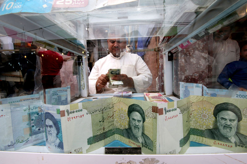 © Reuters. FILE PHOTO: A man counts Iranian rials at a currency exchange shop in Basra, Iraq