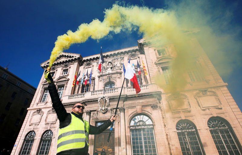 © Reuters. Un manifestante del movimiento de los "chalecos amarillos" sostiene una bengala frente al ayuntamiento durante una manifestación en Marsella