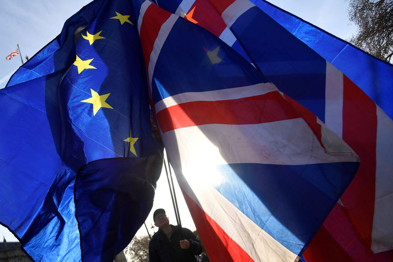 © Reuters. Demonstrators hold EU and Union flags during an anti-Brexit protest opposite the Houses of Parliament in London