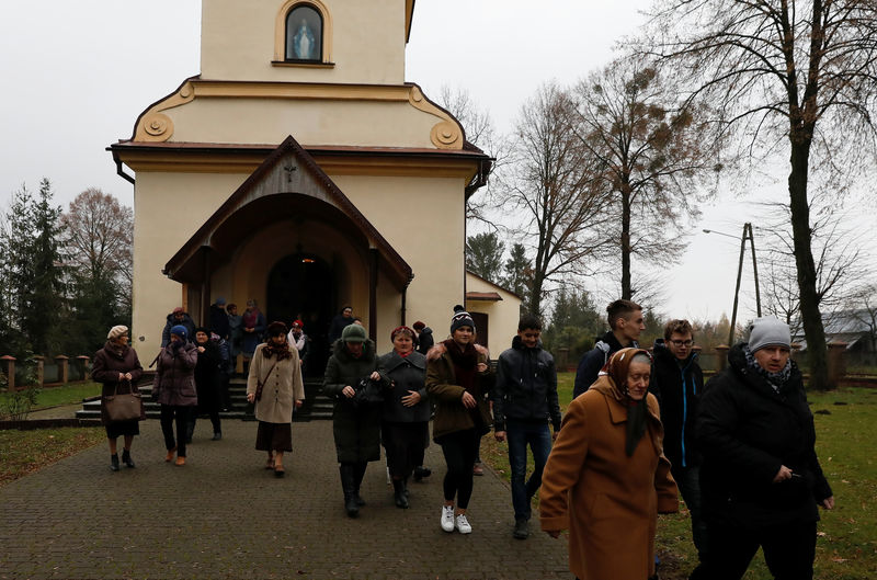 © Reuters. Los feligreses abandonan la iglesia después de la misa en Kalinowka