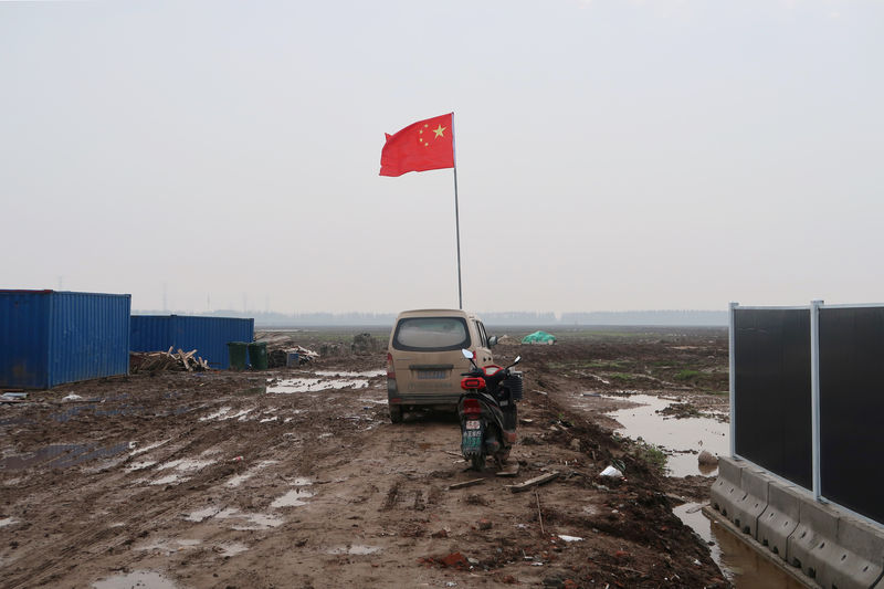 © Reuters. Bandeira da China em terreno onde será construída fábrica da Tesla em Xangai