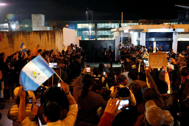 © Reuters. Personas esperan en un acceso del Aeropuerto Internacional La Aurora por el vehículo que transporta a Yilen Osorio, un miembro de la comisión anticorrupción de Naciones Unidas (CICIG), que fue retenido a su arribo el sábado, en Ciudad de Guatemala