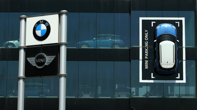 © Reuters. A Mini car is fixed onto a wall at a BMW and Mini dealership in Barcelona