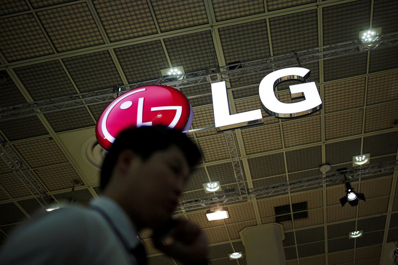 © Reuters. A man talking on his phone walks past the logo of LG Electronics during Korea Electronics Show 2016 in Seoul