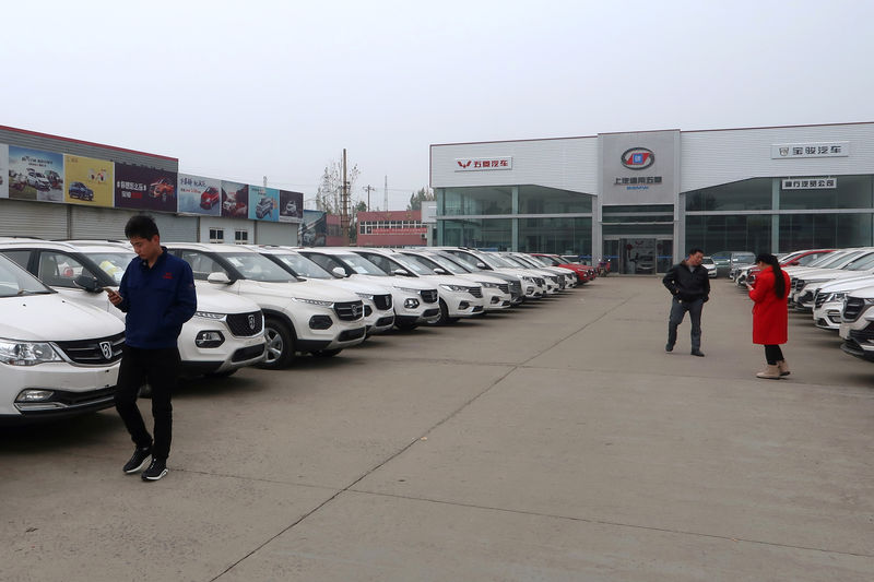 © Reuters. FILE PHOTO: Dealers and customers are seen next to cars at a SAIC-GM-Wuling Baojun dealership in Pingdingshan