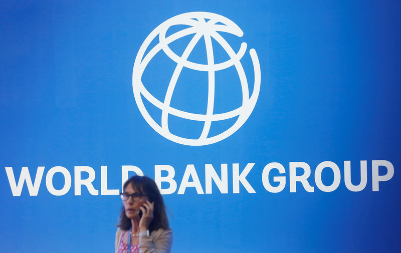 © Reuters. A participant stands near a logo of World Bank at the International Monetary Fund - World Bank Annual Meeting 2018 in Nusa Dua