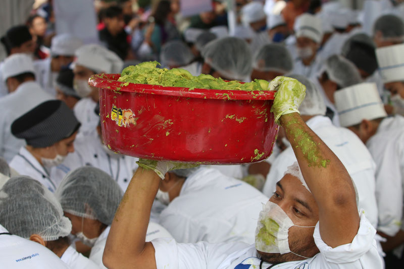 © Reuters. Voluntário de escola de culinária carrega bacia de guacamole no México