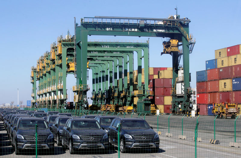 © Reuters. FILE PHOTO: Imported Mercedes Benz cars are seen next to containers at Tianjin Port