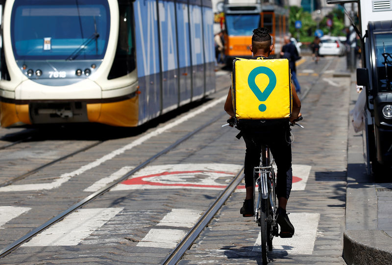 © Reuters. Foto de archivo: Un repartidor en bicicleta de la empresa de envíos Glovo se desplaza por el centro de Milán, Italia