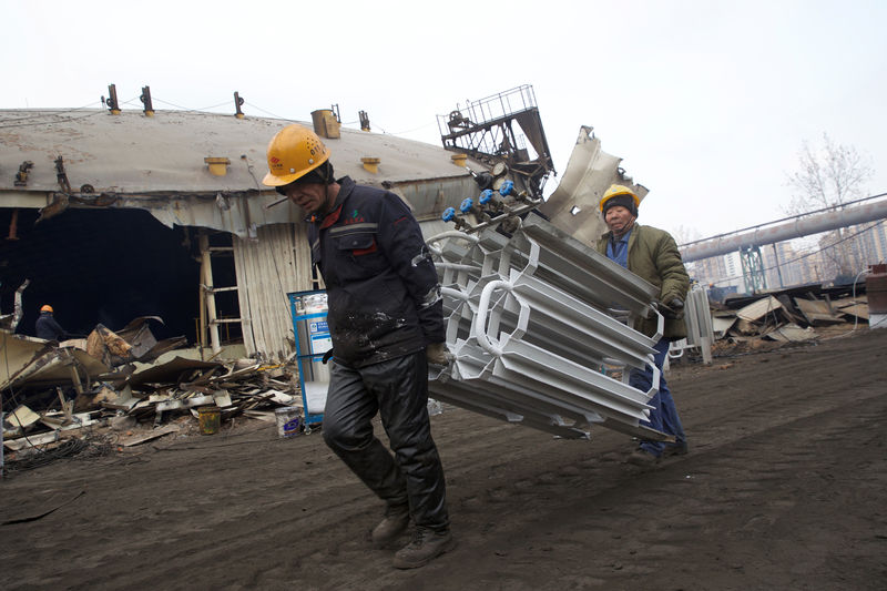 © Reuters. FILE PHOTO: Labourers work on dismantling equipment and facilities at a former steel factory of Jigang, in Jinan