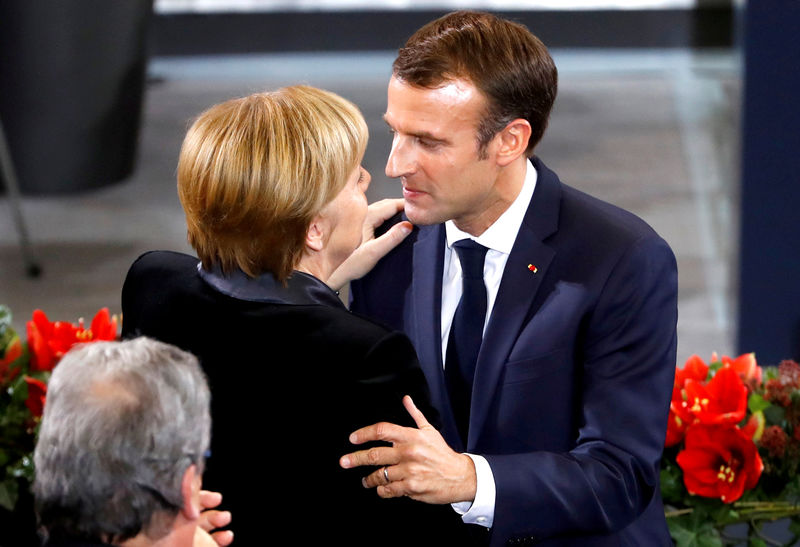 © Reuters. French President Emmanuel Macron hugs German Chancellor Angela Merkel after giving a speech during a ceremony at the lower house of parliament Bundestag in the Reichstag building in Berlin to mark National Mourning Day