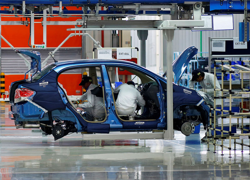 © Reuters. FILE PHOTO: Employees work at the assembly line of the Honda Amaze car inside the company's manufacturing plant in Tapukara