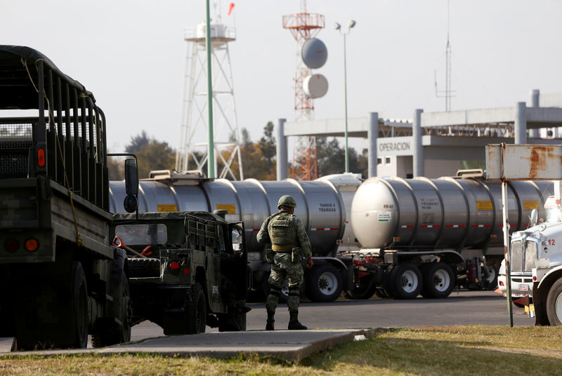 © Reuters. A soldier looks on as tanker trucks wait to load fuel at the storage and distribution terminal El Castillo, in El Salto, on the outskirts of Guadalajara