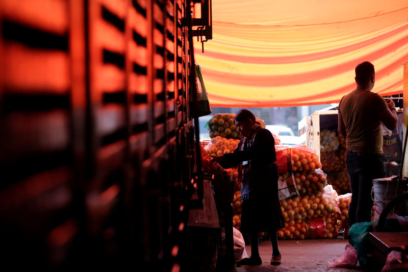 © Reuters. A woman looks at a bag with oranges at the wholesale market "Central de Abastos" in Mexico City